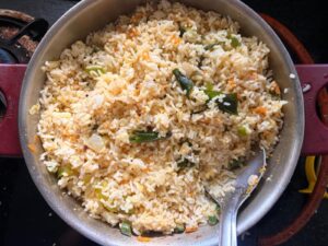 Vegetable masala mixed with rice in a kadai before adding eggs for egg fried rice
